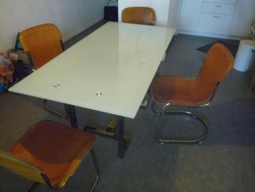 Glazen tafel met 4 leren stoelen beschikbaar voor biedingen