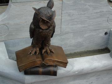 Standbeeld van een uil op bronzen boeken beschikbaar voor biedingen