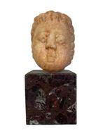 Tête d’enfant en marbre ancien à identifier