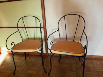  2  zwart ijzeren stoelen met zitkussen beschikbaar voor biedingen