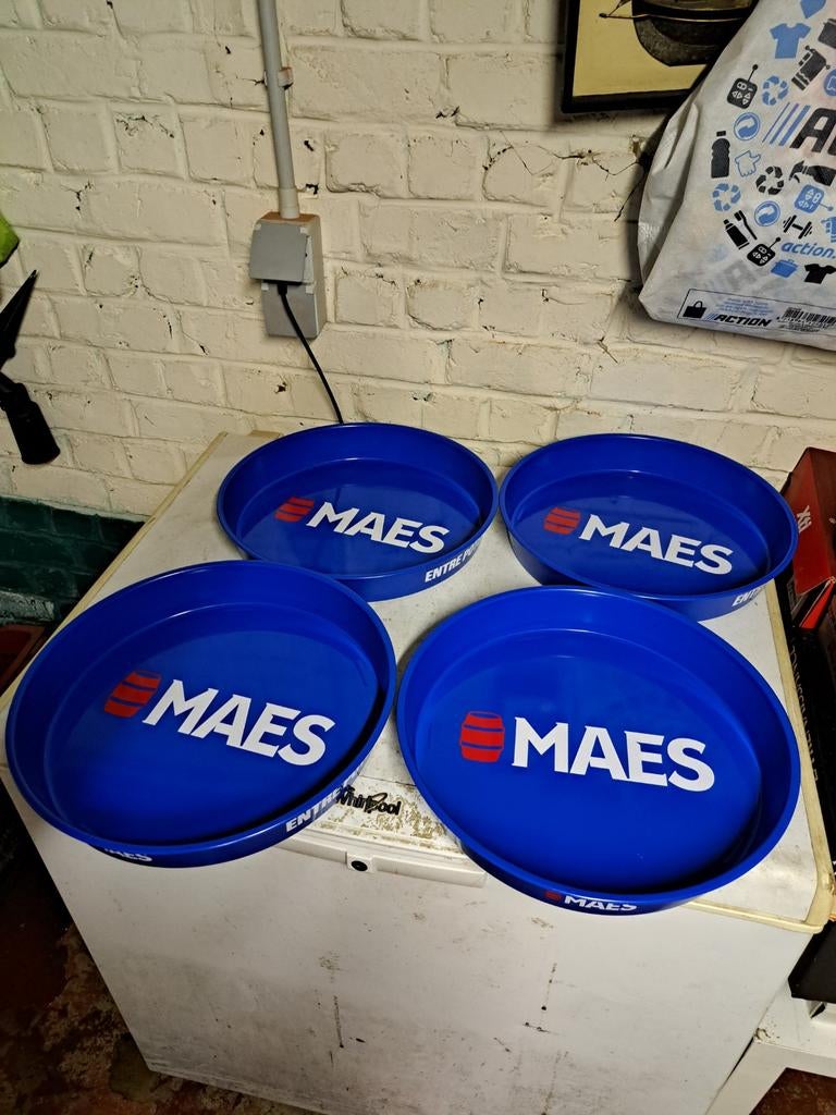 Des plateaux publicitaires de la marque de bière belge Maes.