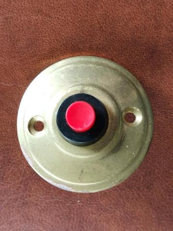 oude koperen deurbel met rode knop