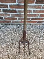 Een drietand tuinhark., Ophalen