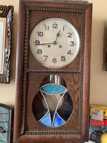 Antieke wandklok met slinger beschikbaar voor biedingen