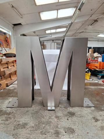 Prachtig M logo in inox reclame beschikbaar voor biedingen