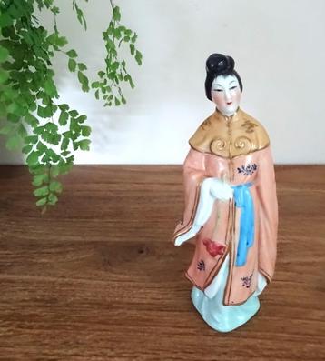 Sierlijke aziatische dame in traditionele klederdracht beschikbaar voor biedingen