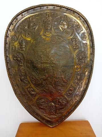Metalen schild in reliëf met afgebeelde strijders beschikbaar voor biedingen