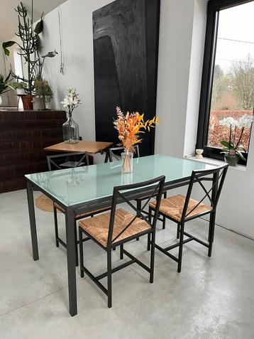 Mooie stalen tafel met glazen blad en vier stoelen 