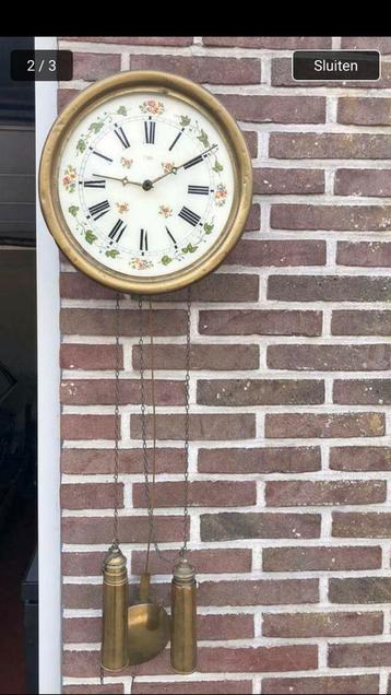Antieke, koperen hang-wandklok beschikbaar voor biedingen