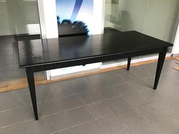 Zwarte houten tafel beschikbaar voor biedingen