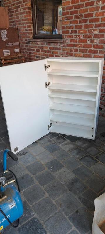 Smalle, witte hangkast met legplanken beschikbaar voor biedingen