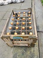 Houten bak met oude lege Colaflesjes, Ophalen