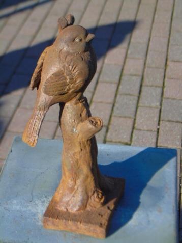 Een vogel op een roestige gietijzeren tak. beschikbaar voor biedingen