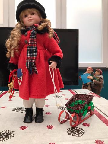 Porceleinen pop met slede en Kerstuitrusting. beschikbaar voor biedingen