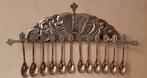 12 cuillères décoratives en métal argenté dans un support su, Antiquités & Art, Enlèvement