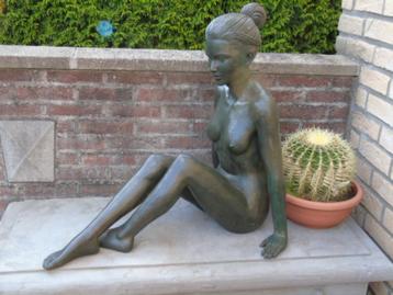 Naakte vrouw met een knotje zittend met groene bronzen hande