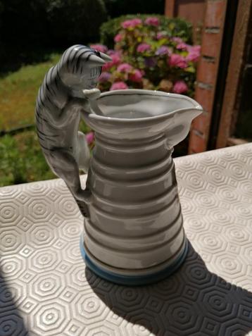 Oud melkkannetje met een katje als handvat beschikbaar voor biedingen