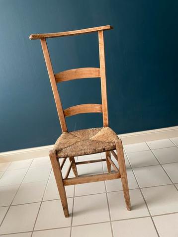 Antiek kerkstoeltje met rieten zitting en hoge rugleuning beschikbaar voor biedingen