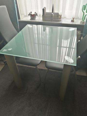 Glazen tafel met twee stoelen beschikbaar voor biedingen