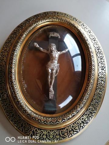 Ovale globe met zilveren christus. Gouden lijst