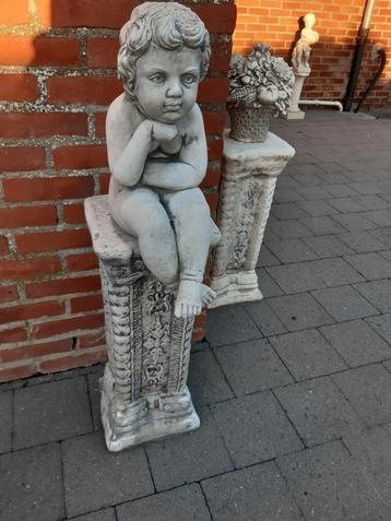 Tuinbeeld.  Denker zittend op sokkel. beschikbaar voor biedingen