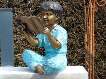 bronzen beeld van een jongen die aan het boek zit, super!  