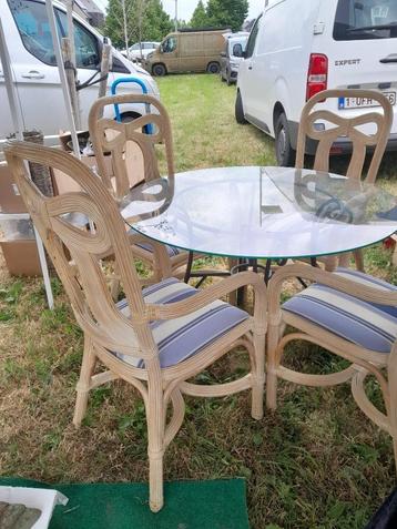 tafel met glazen blad en rieten stoelen beschikbaar voor biedingen