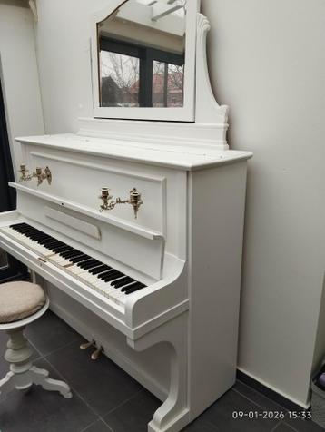 Een oude piano geverfd samen met originele kruk en spiegel.