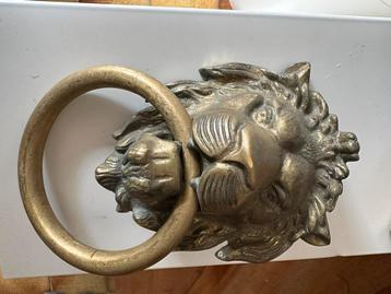 Poignet de porte tête de lion en cuivre.