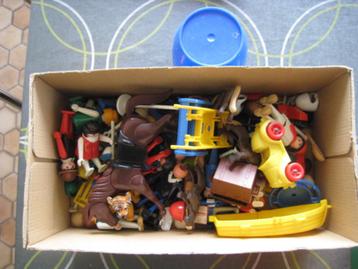 Boîte avec Playmobil en vrac, entre autres