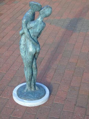 modern bronzen kunstbeeld op een blauwe stenen sokkel. beschikbaar voor biedingen