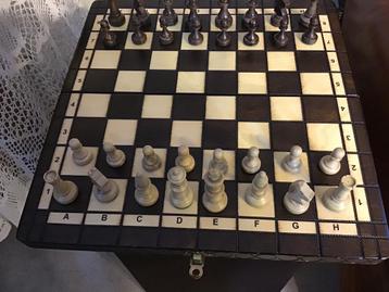 Schaakspel met houten vouwbord en houten schaakstukken.