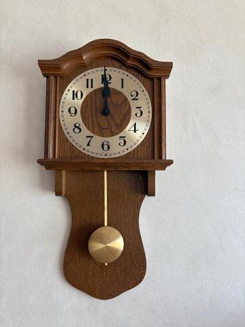 Klassieke eikenhouten wandklok met messing slinger beschikbaar voor biedingen