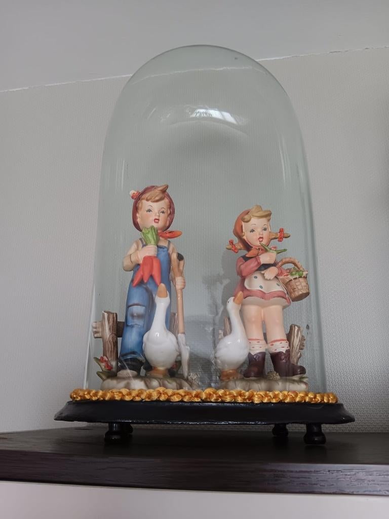 Beeldjes onder antieke globe., Ophalen