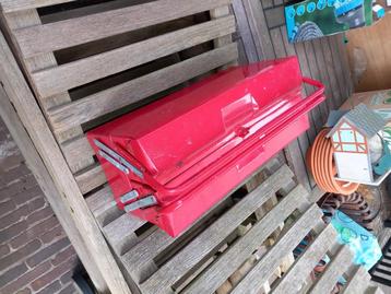 Rode metalen gereedschapskist beschikbaar voor biedingen