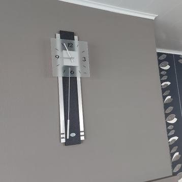 Moderne wandklok met slinger beschikbaar voor biedingen