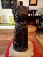 Belle statue sur un socle en marbre qui présente une robe (
