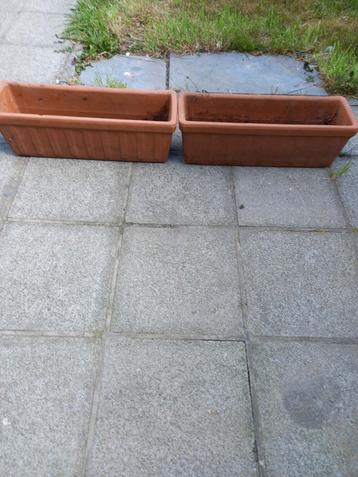 Twee identieke terracotta bloempotten beschikbaar voor biedingen