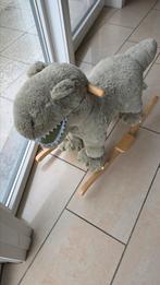 De afbeelding toont een pluche dinosaurus die een schommelt,, Ophalen